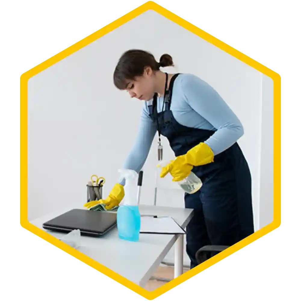 Cleaner wiping desks and sanitizing an office space.